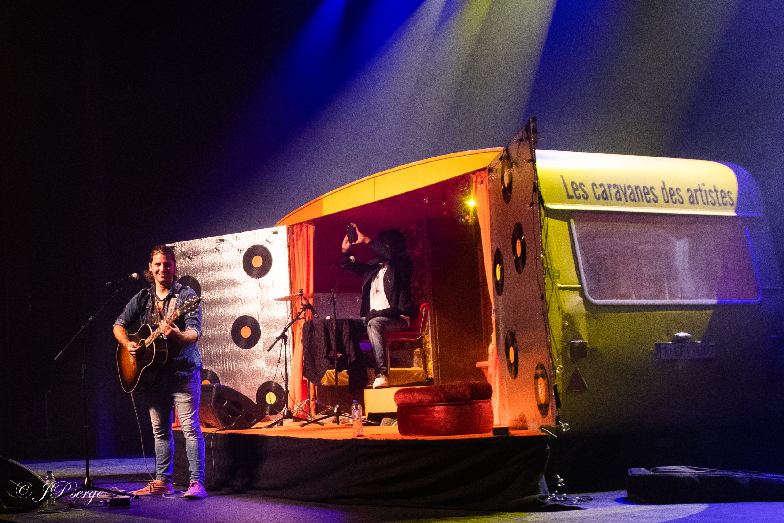 Une caravane transformée en scène de concert, éclairée sous les projecteurs