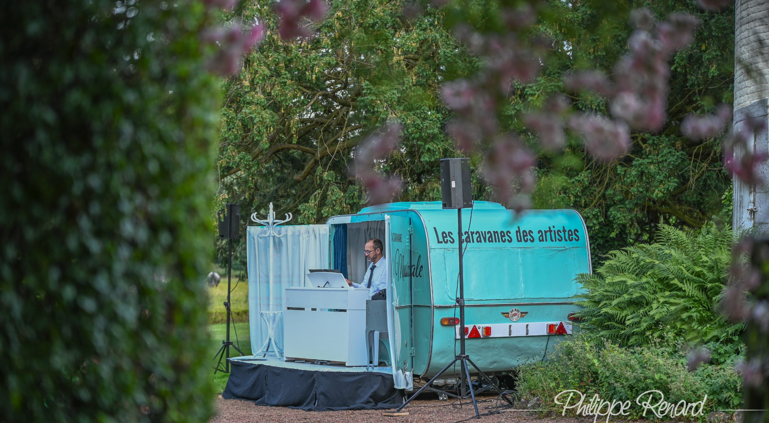 La caravane-scène installée dans un jardin arboré lors d’une précédente édition